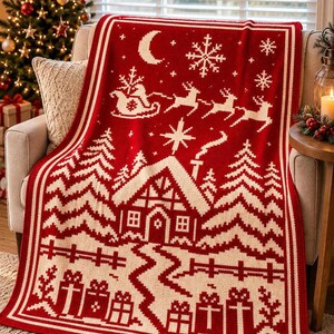 May include: A rectangular knit throw blanket featuring a red and white holiday pattern. The design displays a winter scene with a cabin, pine trees, a fence, wrapped gifts, a crescent moon, snowflakes, and a sleigh pulled by reindeer.