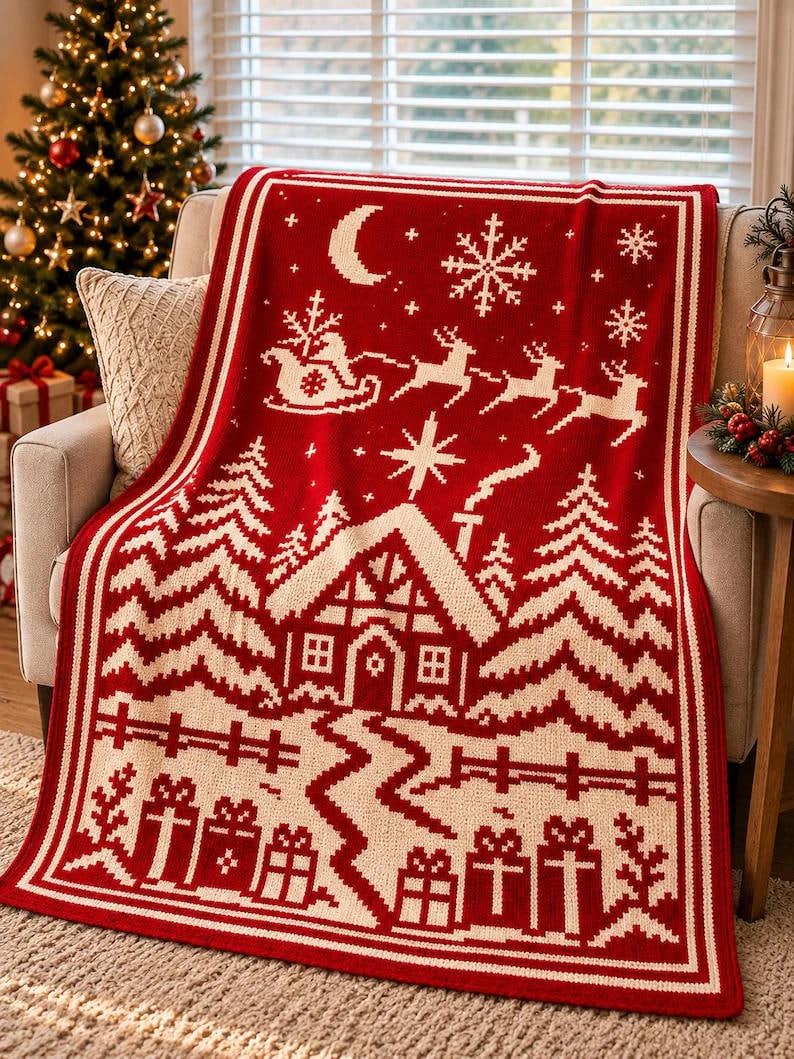 May include: A rectangular knit throw blanket featuring a red and white holiday pattern. The design displays a winter scene with a cabin, pine trees, a fence, wrapped gifts, a crescent moon, snowflakes, and a sleigh pulled by reindeer.