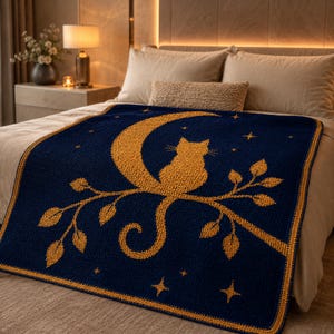 May include: A navy blue throw blanket featuring a gold cat silhouette perched on a crescent moon and branch. The blanket has a gold border and scattered gold stars. The design is a cozy, celestial theme.