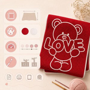 May include: A red crocheted towel with a white teddy bear design and the word "LOVE". The towel has a white border and is folded. Crochet hooks and a ball of yarn are visible.