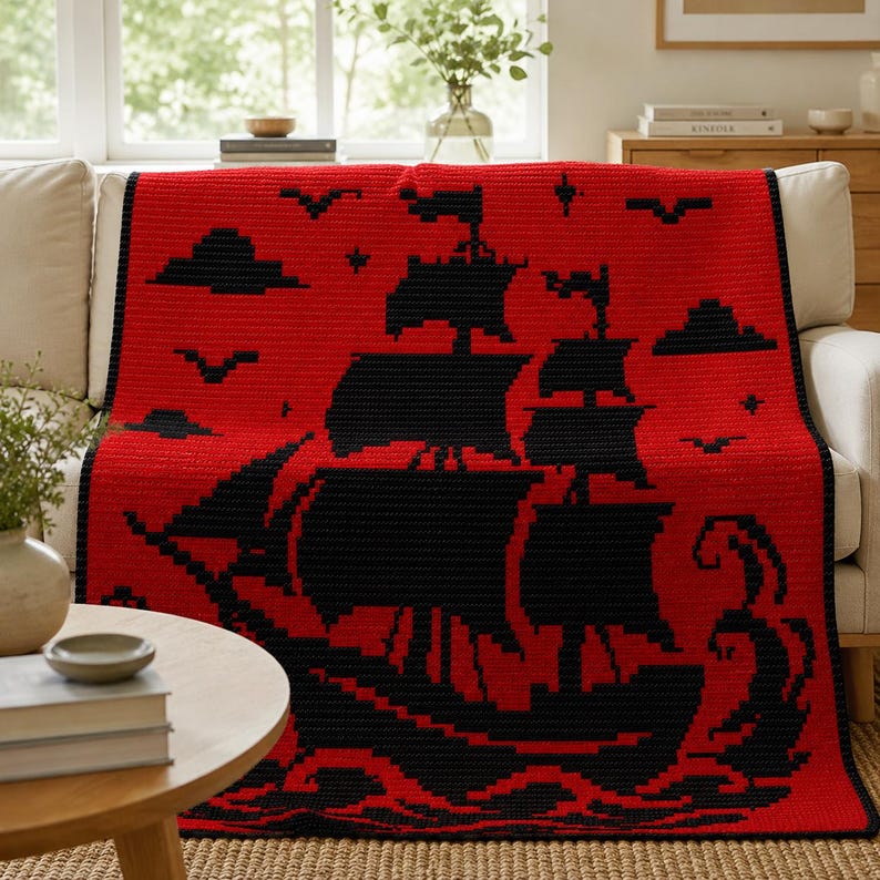 May include: A rectangular crochet blanket featuring a vibrant red background with a large, detailed black silhouette of a sailing ship. The design includes black clouds, birds, and stylized waves at the bottom, all rendered in a pixelated style.
