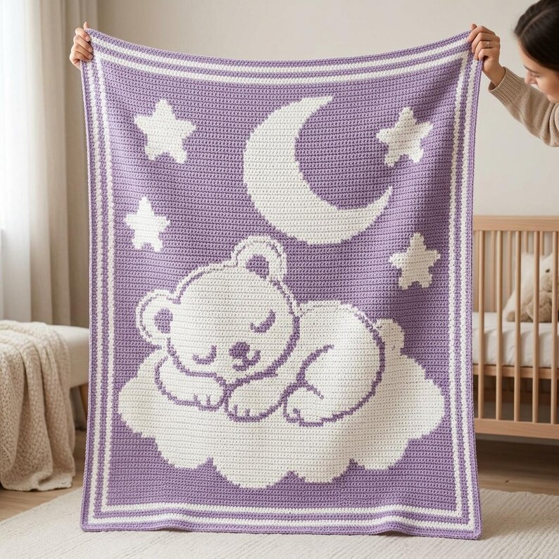 May include: A rectangular crochet blanket featuring a lavender purple background with a white border. The design displays a white sleeping bear resting on a cloud, accompanied by a large crescent moon and three stars in the upper section.