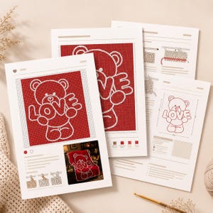 May include: Four sheets of paper with a red and white teddy bear design that says "LOVE". The sheets include instructions and a color chart for a crochet project. A crochet hook and yarn are also visible.