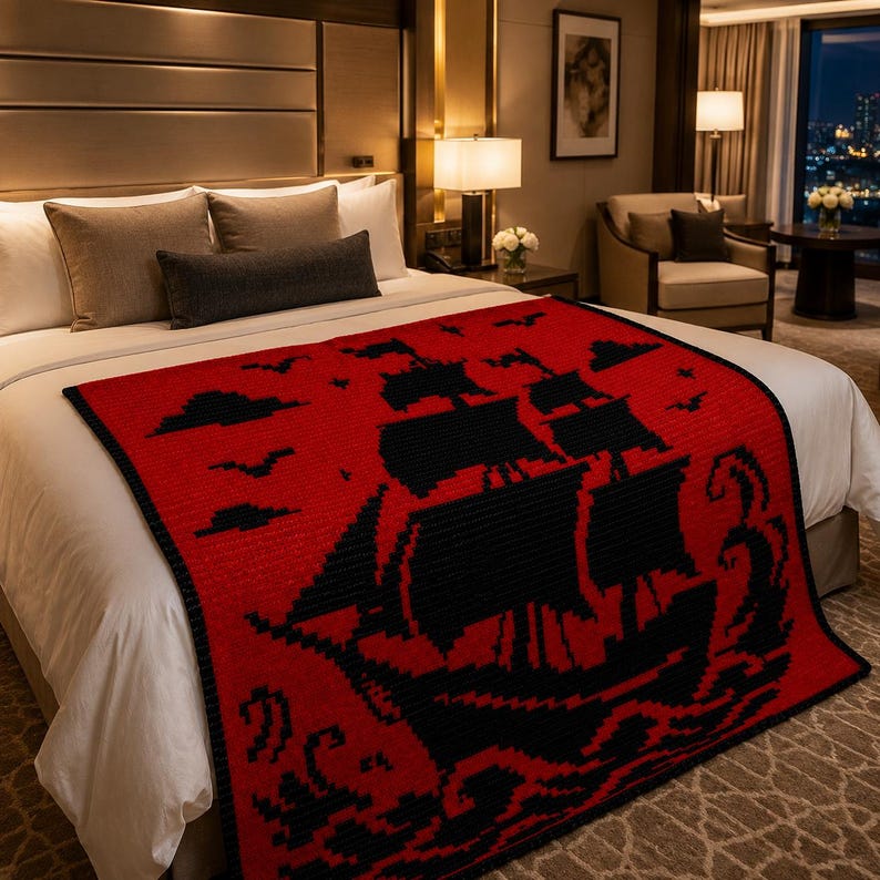 May include: A rectangular blanket featuring a vibrant red background with a prominent black graphic design of a sailing ship on the ocean. The design includes black silhouettes of clouds and birds in the sky, with stylized waves at the bottom.