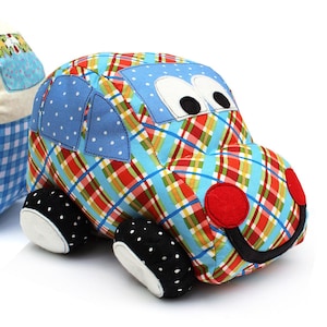 May include: A blue and red plaid toy car with black and white polka dot wheels and a smiling face. The car has a blue and white polka dot window and large black eyes.