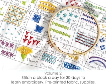 May include: A white fabric sampler featuring a grid of numbered embroidery stitch patterns, including lattice, woven circles, and tassel flowers. A wooden embroidery hoop frames a section of the fabric, which includes text labels for each stitch type.