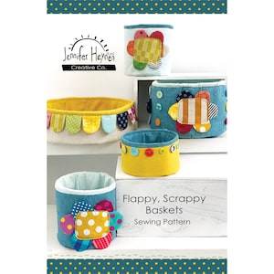 May include: A sewing pattern for "Flappy, Scrappy Baskets" by Jennifer Heynen Creative Co. The pattern features colourful fabric baskets with flower embellishments.