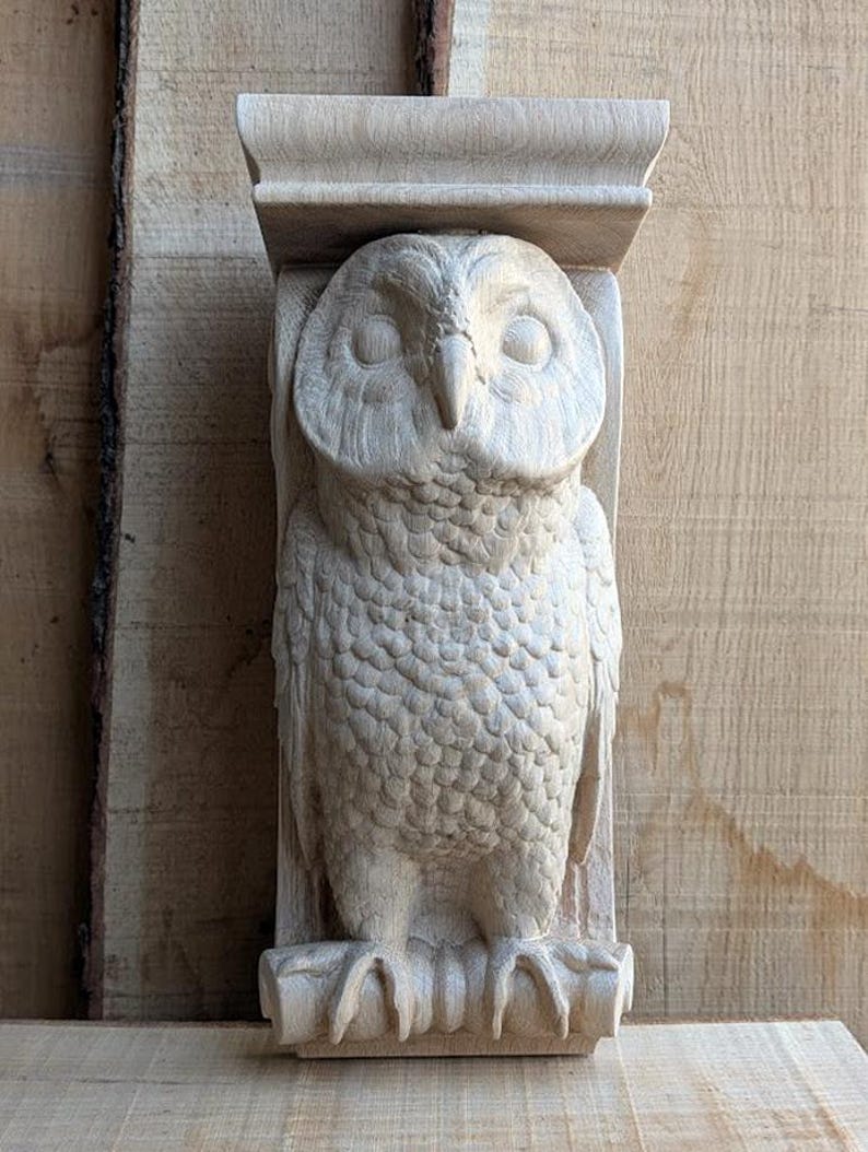 Op de afbeelding: Een houten uilensculptuur met gedetailleerde houtsnijwerk, geperst op een plank. De uil heeft een natuurlijke houtkleur en is een decoratief stuk voor een huis of tuin.