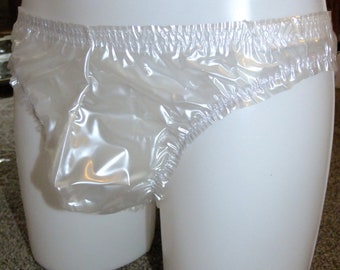 May include: Clear plastic underwear with an elasticated waistband. The underwear is displayed on a white mannequin. The material appears waterproof and slightly translucent.