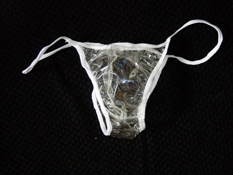 May include: A clear plastic disposable underwear with white elastic trim. The underwear is designed for use in a medical or beauty setting.