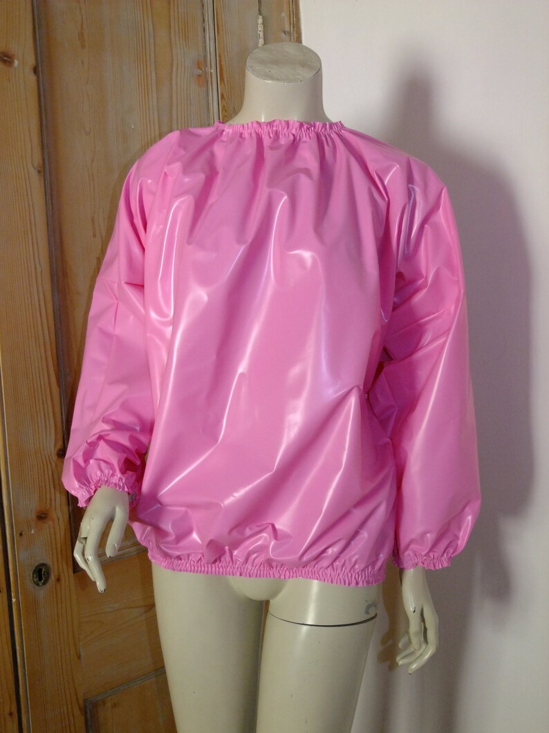 May include: A pink, shiny, long-sleeved shirt with elastic cuffs and a gathered neckline.