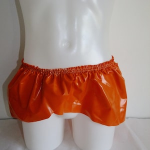 Könnte beinhalten: Orangener Gummiskirt mit einem gerafften elastischen Bund.