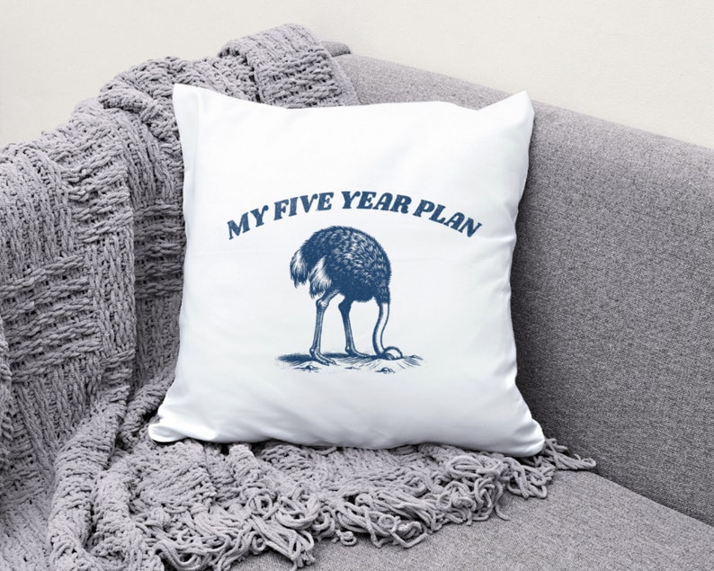 K&ouml;nnte beinhalten: Ein wei&szlig;es Kissen mit einer blauen Illustration eines Strau&szlig;es, der seinen Kopf in den Sand steckt, und dem Text "My Five Year Plan".