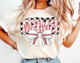 May include: A white t-shirt with a black and white chequered design featuring the word "MAMA" in red letters with baseballs inside the letters. A red and white baseball-themed bow is below the word.