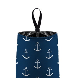 May include: A blue fabric trash can with a black handle and a white anchor pattern.