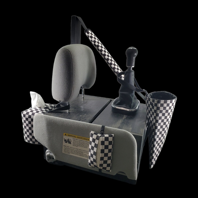 May include: Black and white chequered car seat organiser with multiple pockets and a warning label that reads "Warning:  Avertir:  Attenzione:  Achtung:  Waarschuwing:  Aviso:  Avvertenza:  Ostrzeżenie:  Aviso:  Keikoku".