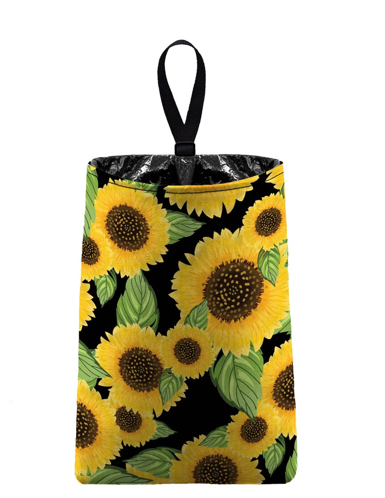 May include: A black trash can with a sunflower pattern. The trash can has a black handle and is made of fabric.