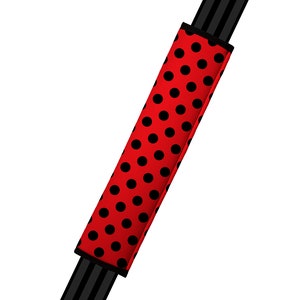 May include: Red and black polka dot car seatbelt cover.