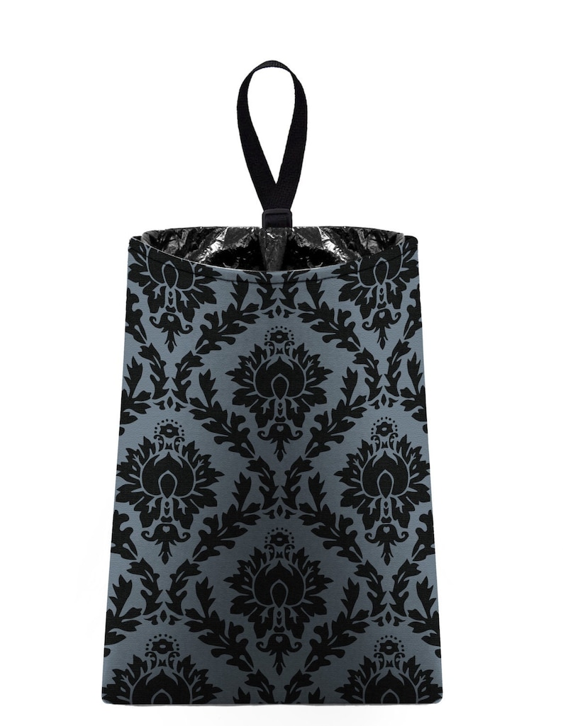 May include: A gray and black patterned fabric trash can with a black hanging loop. The trash can has a damask pattern.