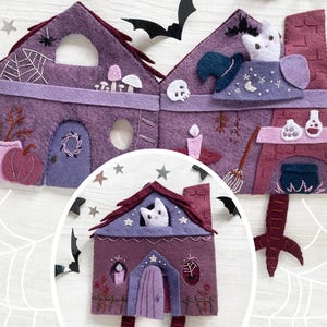 May include: A felt Halloween-themed house in shades of purple and burgundy. The house features a pumpkin, a spiderweb, a cat, a witch's hat, and other spooky decorations. The house is decorated with stars, bats, and a witch's broom.
