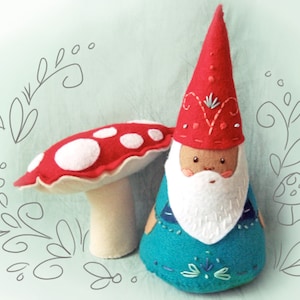 May include: A felt gnome with a red hat and a white beard, holding a red and white mushroom. The gnome is wearing a blue and green outfit with embroidered details.