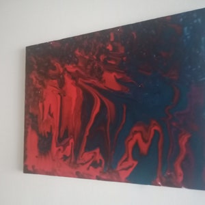 May include: Abstract painting with swirling red, black, and blue paint. The colours blend together to create a dynamic and energetic composition.