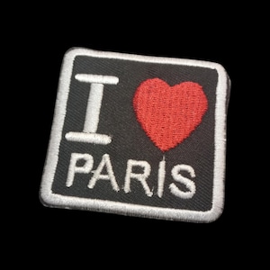 May include: Black and white embroidered patch with the text "I love Paris" and a red heart.