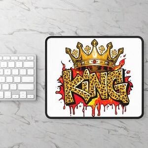 May include: A white mousepad with a black border featuring a gold crown above the word "KING" in a leopard print font. The word is set against a red and yellow flame design.