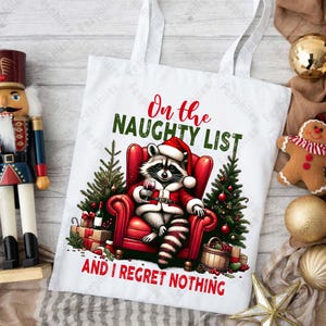 May include: White tote bag with a red and black raccoon wearing a Santa hat and holding a glass of wine. The text on the bag reads "On the Naughty List and I Regret Nothing."