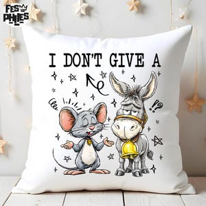 May include: White square throw pillow with a cartoon illustration of a mouse and a donkey. The mouse is gray with pink ears and the donkey is gray with a gold bell. The text "I DON'T GIVE A" is printed on the pillow.