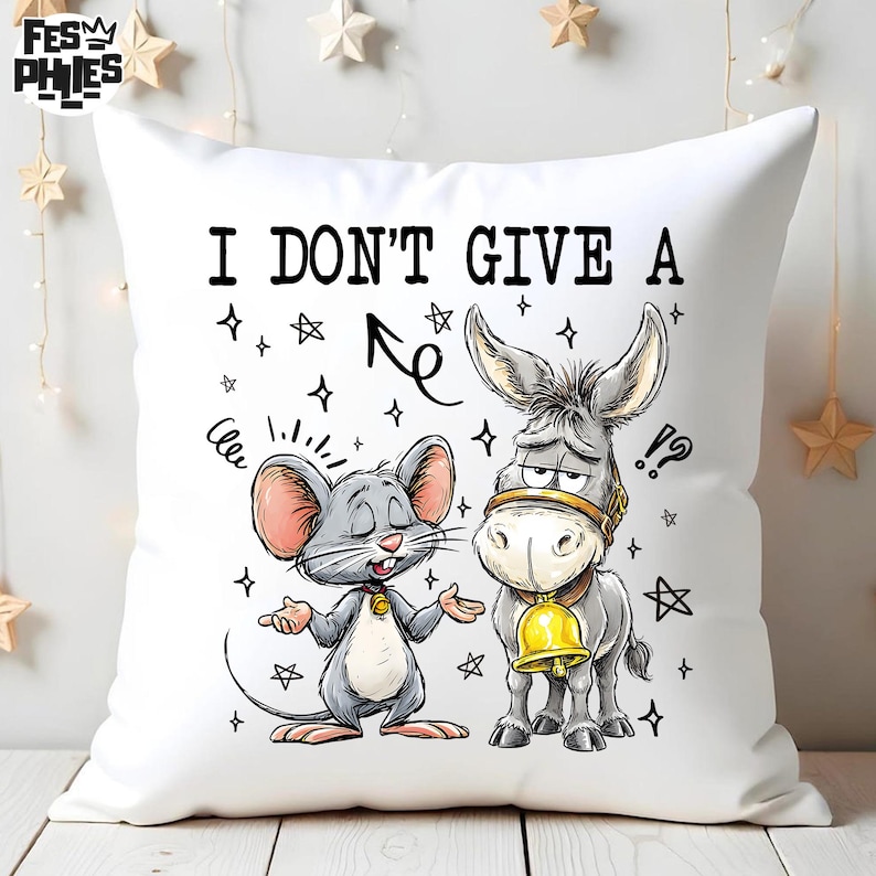 May include: White square throw pillow with a cartoon illustration of a mouse and a donkey. The mouse is gray with pink ears and the donkey is gray with a gold bell. The text "I DON'T GIVE A" is printed on the pillow.