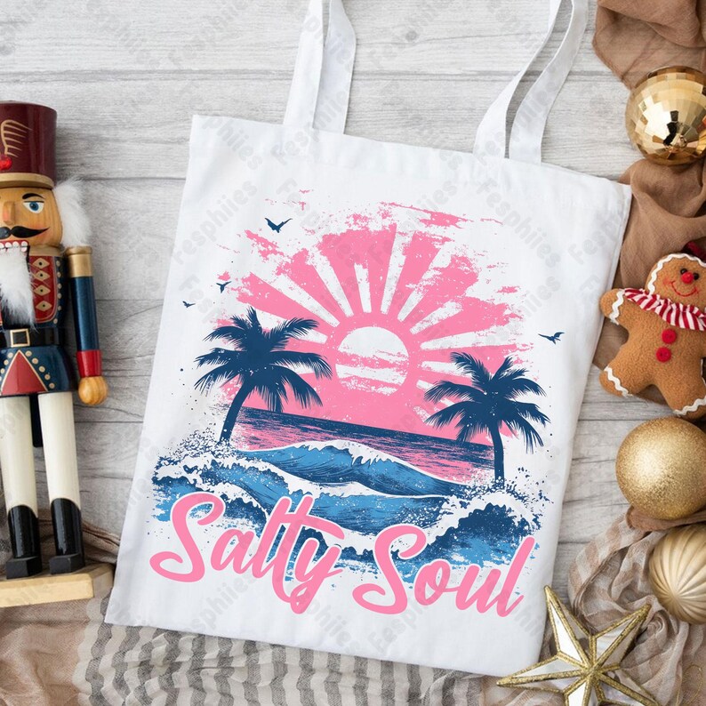 May include: White tote bag featuring a pink and blue sunset graphic, palm trees, and ocean waves. The text "Salty Soul" is written in pink letters.