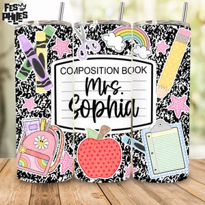 May include: A cylindrical tumbler with a black and white composition notebook pattern featuring school-themed graphics including a yellow pencil, a red apple, a pink backpack, a rainbow, scissors, and a clipboard. The text reads COMPOSITION BOOK Mrs. Sophia.