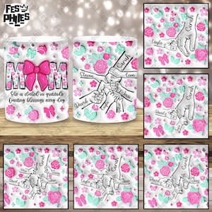May include: White ceramic mug with a pink and green floral design. The mug features a pink bow with the word "MOM" in the center. The text "She is clothed in gratitude Counting blessings every day" is printed below the bow. The mug also features a design of hands holding each other with the names "Sarah", "Leon", "Jessi", "Peter", "Cayla", "David", and "Steven" written on the fingers.