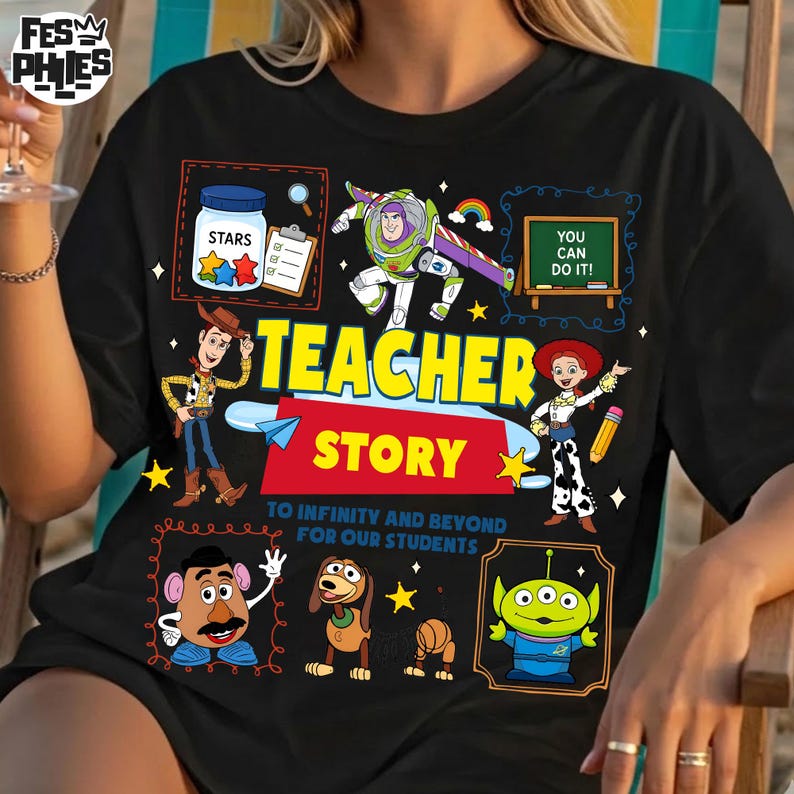 May include: Black t-shirt featuring a colorful graphic design with characters and text from the movie "Toy Story." The design includes the words "Teacher Story" and "To Infinity and Beyond for Our Students," along with images of Woody, Buzz Lightyear, and other characters.