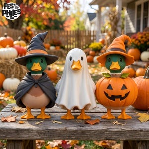 May include: Three mallard duck figurines on a wooden surface. The left duck wears a black witch hat and cape. The center duck is covered by a white ghost sheet. The right duck wears an orange witch hat and sits inside a carved pumpkin.