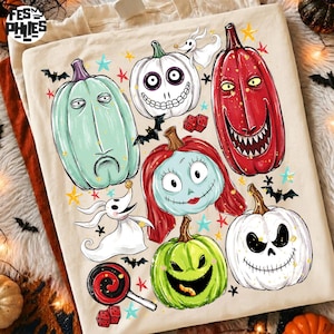 May include: A cream-colored t-shirt featuring a graphic print of various characters and pumpkins from The Nightmare Before Christmas, including Zero, Sally, and Jack Skellington, surrounded by small bats, stars, and red dice.