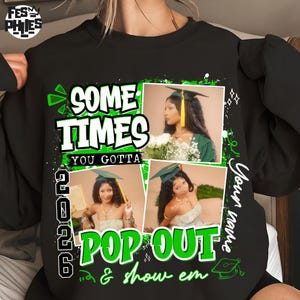 May include: Black sweatshirt with a graduation theme. The design includes the text "SOME TIMES YOU GOTTA POP OUT & show em" in green and white. It also features three photos of a graduate wearing a cap and gown. The year "2026" is also displayed.