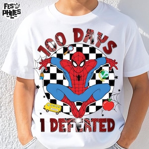 Puede incluir: Camiseta blanca con un diseño de Spider-Man rojo y azul. El diseño incluye el texto "100 DAYS" y "I DEFEATED" en rojo, junto con ilustraciones escolares como un autobús, una manzana y un globo terráqueo.