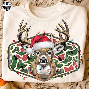 May include: Cream-colored sweatshirt featuring a deer wearing a Santa hat and a string of colorful Christmas lights. The deer is set against a camouflage pattern with birds. The sweatshirt has a crew neck.