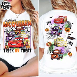 May include: A white t-shirt featuring a graphic print of Lightning McQueen and other characters from the Cars franchise. The design includes Halloween elements like pumpkins, spider webs, bats, and the text Lightning McQueen Trick or Treat.