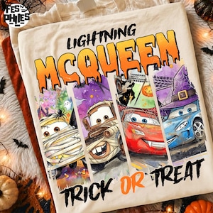 May include: A cream-colored t-shirt featuring the text LIGHTNING MCQUEEN and TRICK OR TREAT. The graphic displays four vertical panels showing cartoon cars dressed in Halloween costumes, including a mummy, a vampire, and a witch.