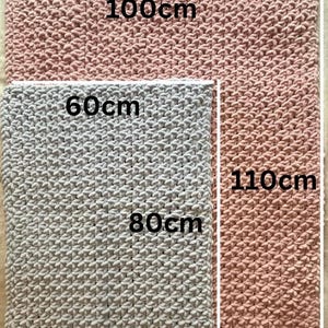 May include: Two knitted blankets, one light gray and one pink, with measurements in centimeters. The gray blanket is 80cm by 60cm and the pink blanket is 110cm by 100cm.