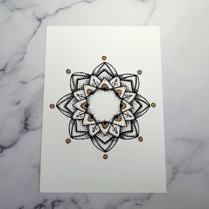May include: A black and white mandala with gold accents. The mandala is drawn in a detailed style with intricate patterns and designs.