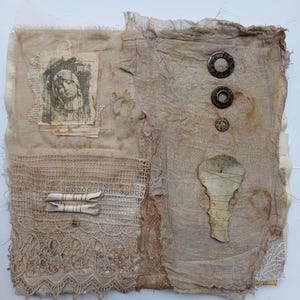 May include: Textile art piece with a collage of textures and elements. Features a vintage portrait, lace, metal embellishments, and a keyhole shape. The colour palette is primarily neutral tones of beige and brown.