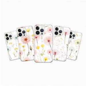 Puede incluir: Cinco fundas de teléfono con fondo blanco y diseño floral en acuarela. El diseño presenta flores rosas, amarillas y blancas con tallos y hojas verdes. Las fundas son para un smartphone.