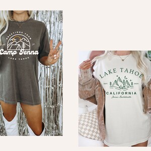 Op de afbeelding: Twee vrouwen dragen oversized t-shirts met grafische ontwerpen. Het eerste shirt is grijs met witte tekst die "Greetings from Camp Jenna Lake Tahoe" luidt. Het tweede shirt is wit met groene tekst die "Lake Tahoe Est. 2020 California Jenna's Bachelorette" luidt.