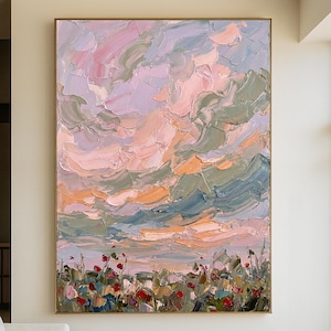 Puede incluir: Gran pintura al óleo enmarcada que representa una vibrante puesta de sol con pinceladas texturizadas. La obra presenta un cielo de tonos rosa, lavanda y naranja, con formaciones de nubes verdes y azules. Un campo de flores rojas y verdes se encuentra en la parte inferior.
