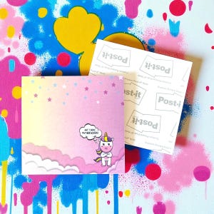 Op de afbeelding: Een vierkant Post-it notitieblok met een roze en gele gradiënt achtergrond, versierd met sterren en wolken. Een cartoon eenhoorn met gekruiste armen en de tekst "NOT TODAY, MOTHERFUCKERS!" is afgebeeld. Een tweede Post-it notitieblok is zichtbaar.