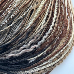 May include: A collection of brown, black and blonde synthetic dreadlocks. The dreadlocks are made of kanekalon hair and are ready to be installed.